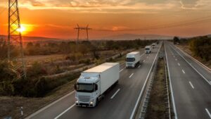 Caminhões transportando cargas em rodovia durante o pôr do sol, representando o gerenciamento de risco no transporte com foco em segurança logística, monitoramento e eficiência operacional.