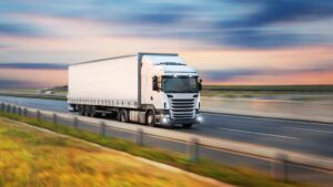 Caminhão de carga em rodovia representando a logística reversa, o transporte rodoviário, a eficiência operacional e a rastreabilidade logística.